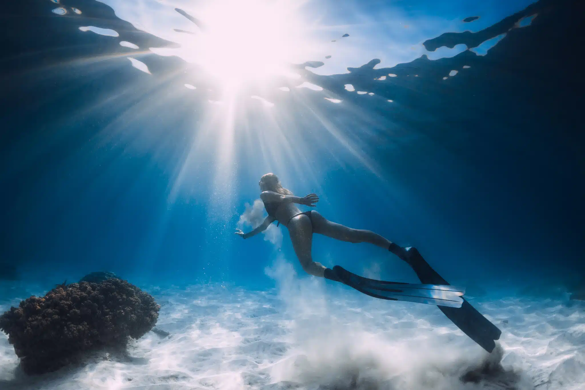 Woman free diving in the crystal clear waters of Hawaii